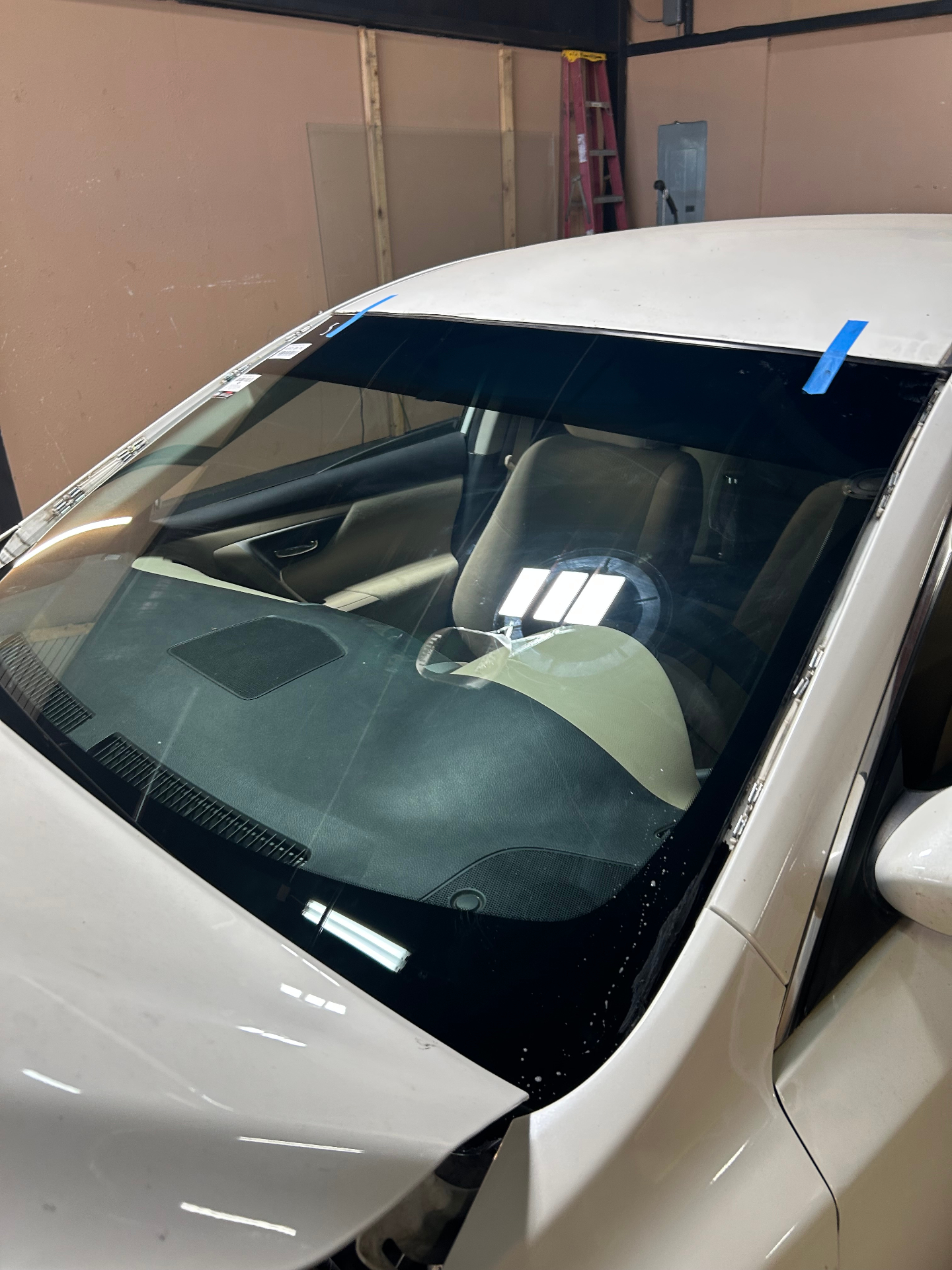 Final windshield install result on white sedan