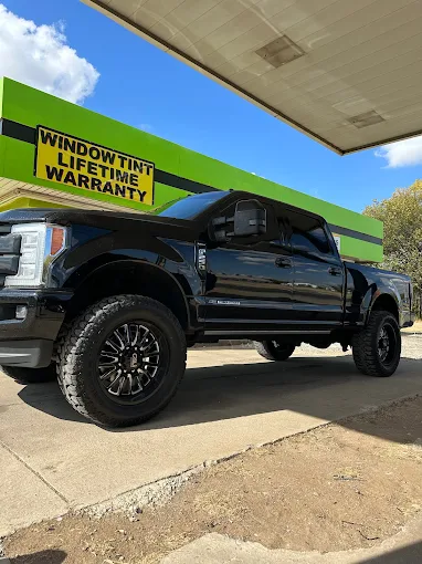 Black pickup truck with freshly installed dark window tint outside the Ponca City shop