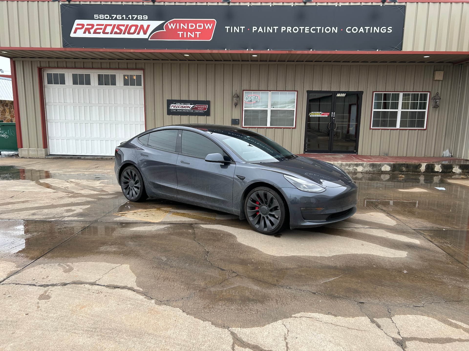 Tesla Model 3 with premium window tint in front of shop